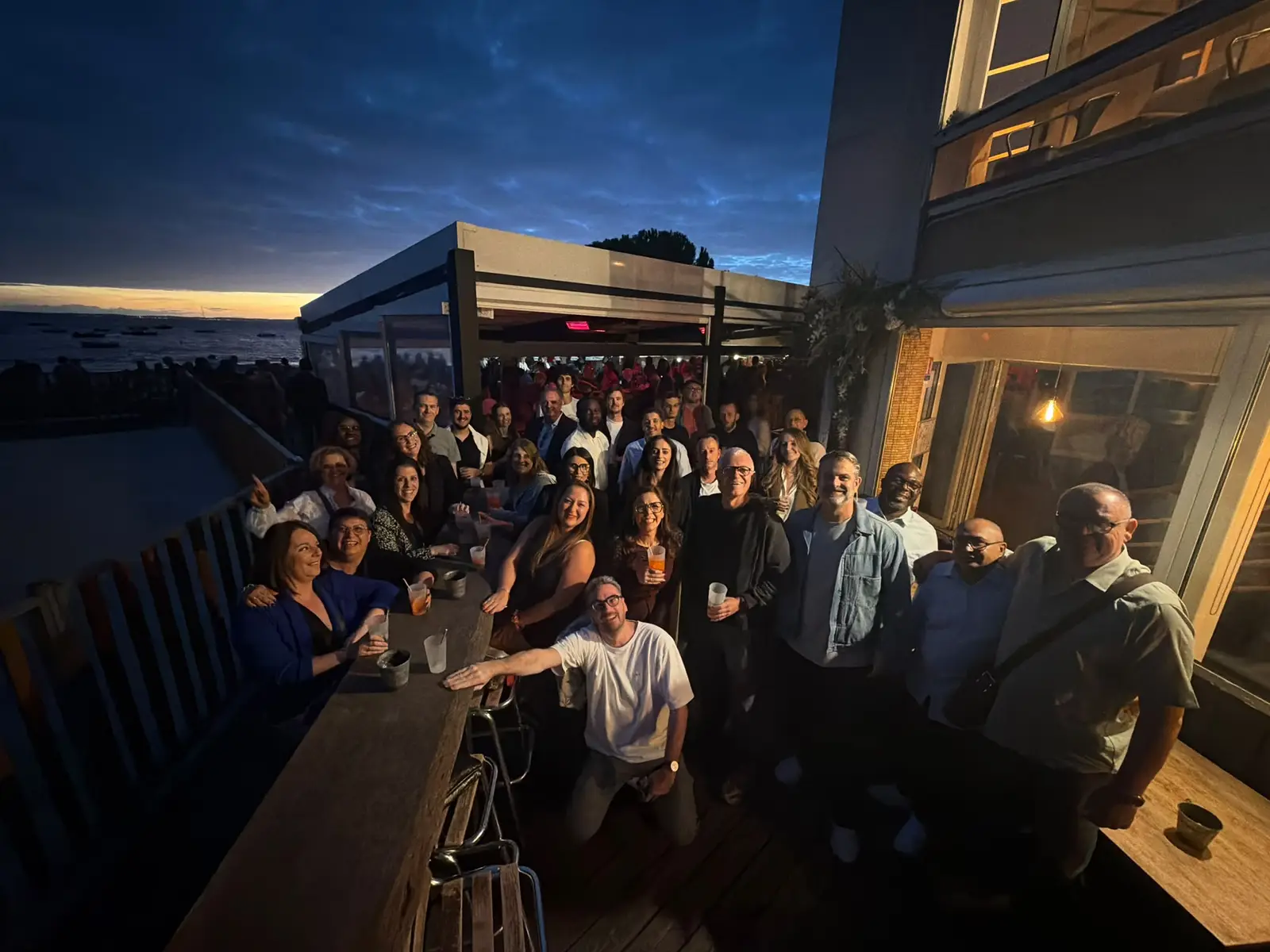 Les collaborateurs de CEO Car Caring et de MoveMyFleet réunis en terrasse à la tombée de la nuit, face au Bassin d’Arcachon