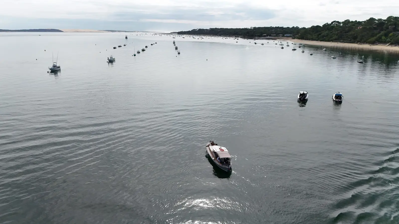 Vue aérienne d’une pinasse naviguant sur le Bassin d’Arcachon, au milieu des bateaux au mouillage